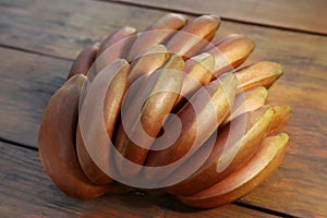 Tasty purple bananas on wooden table, closeup