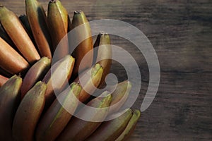 Tasty purple bananas on wooden table, top view. Space for text