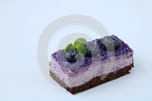 Tasty purple blueberry mousse cake with blueberry and mint leaves on white background, horizontal, side view, copy space