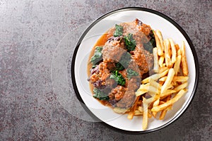 Tasty Rabo de toro or oxtail stew served with french fries on white plate on the table. Horizontal top view