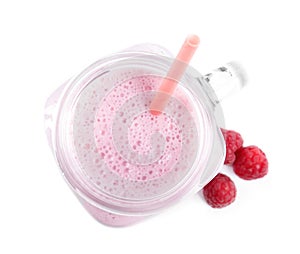 Tasty raspberry milk shake in mason jar and fresh berries isolated on white, top view