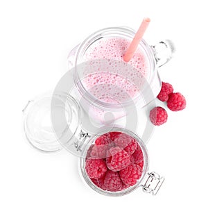 Tasty raspberry milk shake in mason jar and fresh berries isolated on white, top view