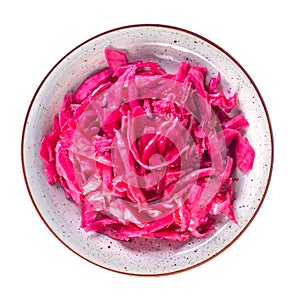 Tasty red sauerkraut or fermented cabbage in marinade on a plate isolated on white