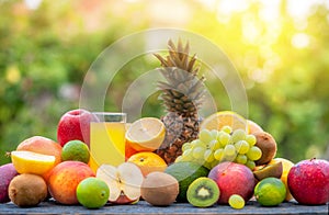 Tasty ripe fruits and a glass of juice on a wooden table