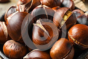 Tasty roasted edible chestnuts in frying pan, closeup