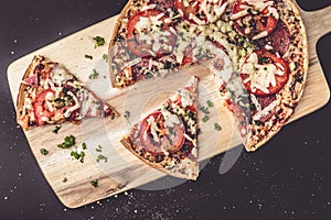 Tasty salami pizza and cooking ingredients tomatoes basil on a background. Top view