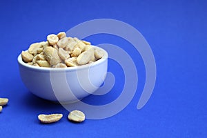 Tasty salted peanuts in a white plate