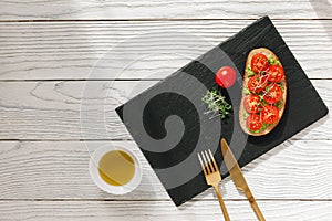 Tasty sandwich with cherry tomatoes, micro greens and avocado on wholegrain bread on light wooden background. Healthy delicious