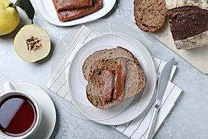 Tasty sandwich with quince paste served for breakfast on light grey marble table, flat lay