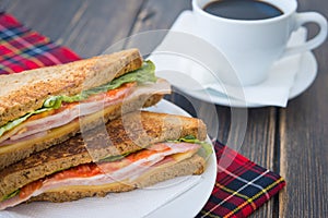 Tasty sandwiches with cheese and bacon and a cup of espresso