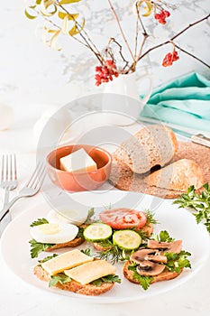 Tasty sandwiches on a plate and forks on a table.