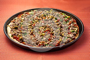 A tasty sardine pizza with olives, tomatoes and onions