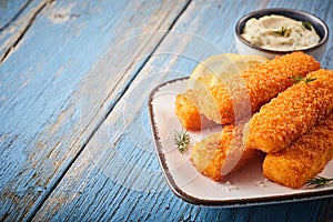 Tasty savory snack of crumbed fish sticks photo