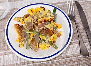 Tasty scrambled eggs with asparagus and mushrooms