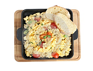 Tasty scrambled eggs with sprouts, cherry tomato and bread in frying pan isolated on white