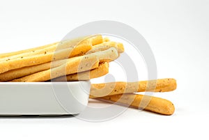 Tasty seaweed breadsticks are housed in white ceramic vessels and placed on a white floor selective focus, space for text