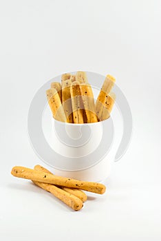 Tasty seaweed breadsticks are housed in white cup vessels and placed on a white floor, space for text