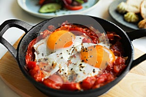 Tasty Shakshouka served in pan on table