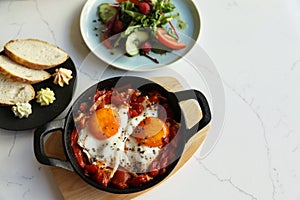 Tasty Shakshouka served on white marble table, flat lay. Space for text