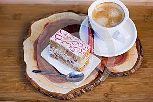 Tasty Slice of Cake with Cream Filling and Heart Decor on Top with Coffee