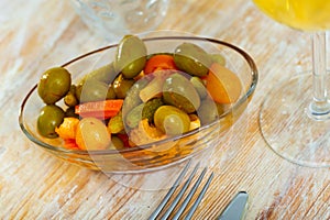 Tasty small serving of olives with carrots pickles and onions