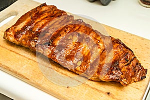 Tasty smoked barbecue ribs on wooden cutting board