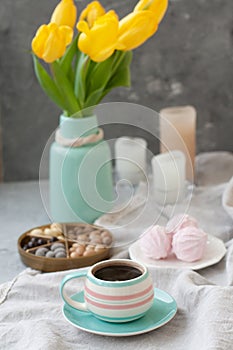A tasty snack: a cup of coffee, a plate of zephyr and a box of sweets