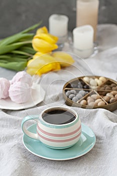A tasty snack: a cup of coffee, a plate of zephyr and a box of sweets