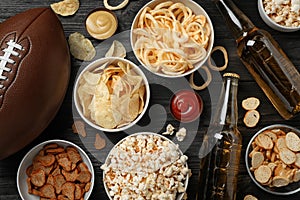 Tasty snacks and beer prepared for watching American football on table