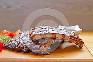 Tasty and Spicy Barbecue Pork Ribs with Grilled Vegetable on Wooden Board