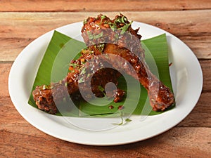 Tasty and spicy Chicken drumstick fry served on wooden background. Dishes and appetizers of indian cuisine, selective focus