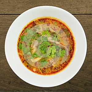 The tasty spicy pork tom yum soup (hot and sour soup) in white ceramic bowl