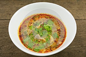 The tasty spicy pork tom yum soup (hot and sour soup) in white ceramic bowl