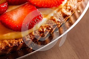 Tasty strawberry tart placed on wooden table