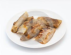 Tasty stuffed cabbage leaf laying on plate on white background