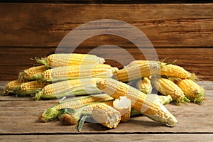 Tasty sweet corn cobs on table