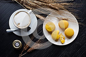 Tasty sweet macarons and coffee cup. Macaroons on black background. Top view.