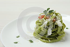 Tasty tagliatelle with spinach and cheese on plate, closeup. Exquisite presentation of pasta dish