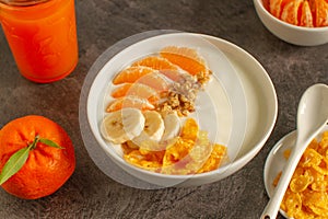 Tasty tangerine smoothie bowl with fruits, cereals, seeds and turmeric powder