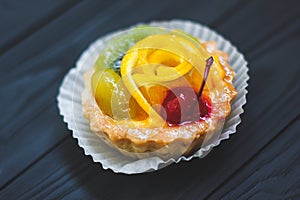 Tasty tartlets with berries on wooden background, top view