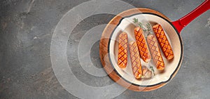 tasty thin sausages in pan. Long banner format. top view. copy space for text