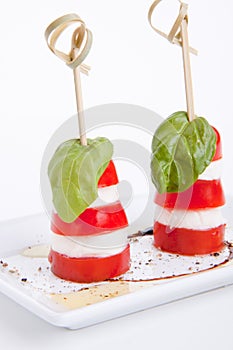 Tasty tomatoe mozzarella salad with basil on white