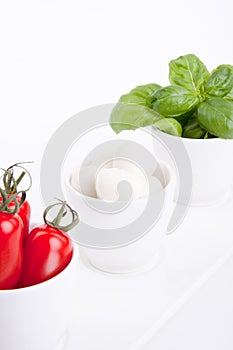 Tasty tomatoe mozzarella salad with basil on white