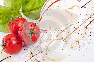 Tasty tomatoe mozzarella salad with basil on white