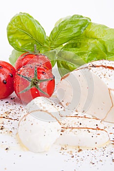 Tasty tomatoe mozzarella salad with basil on white