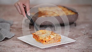 Tasty traditional italian lasagna. Piece of Lasagne on white plate.