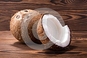 Tasty tropical coconuts on a wooden background. Hawaiian cracked coconut shell and a whole nut. Healthful lifestyle.