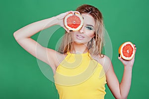 Tasty tropical fruits! Attractive sexual woman with beautiful makeup holding fresh juicy grapefruit or orange near face on isolate