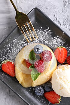 Tasty vanilla fondant with white chocolate, berries and ice cream on light grey textured table, flat lay