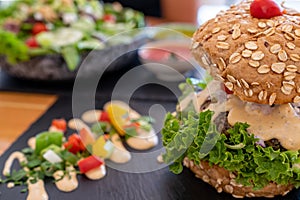 Tasty vegan mushroom burger and mixed field greens salad selective focus